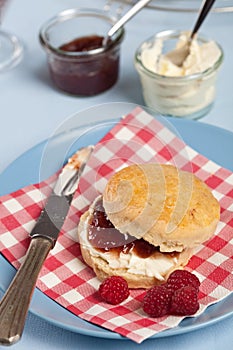Scone with clotted cream and raspberry jam photo