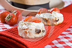 Scone halves with strawberries and clotted cream photo