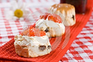 Scone halves with strawberries and clotted cream photo