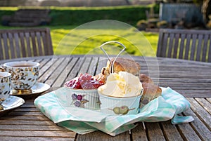 Scones with cups of tea in an English country garden.