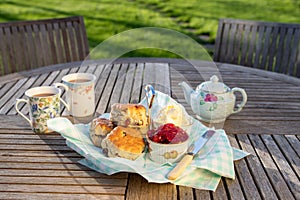 Scones with cups of tea in an English country garden.