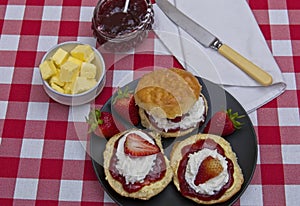 Scones topped with strawberry jam,cream and fresh fruit