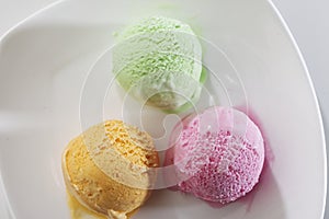 Scoop of delicious real fresh ice cream in Mango, Strawberry and Pistachio flavour. photo