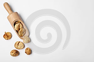 Scoop of dried figs on white background, top view
