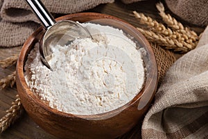 Scoop and flour in a bowl on the old board