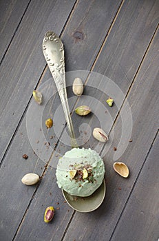 Scoop of homemade pistachio ice cream with chopped pistachios and chocolate