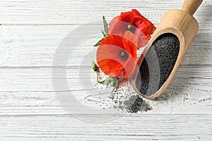 Scoop of poppy seeds and flowers on white wooden table, flat lay