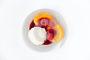 Scoop of Vanilla Ice Cream with Peach Halves, Raspberries and Raspberry Sauce