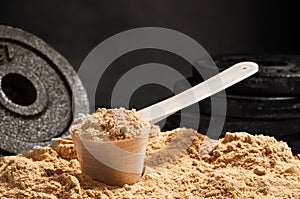 Scoop of whey protein on black background. Chocolate flawour photo