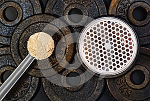 Scoop of whey protein on black background. Top view