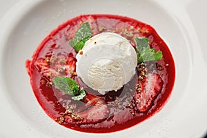 Scoop of white ice cream with fruit in plate. Top view.