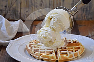 scooping vanilla ice cream onto waffle