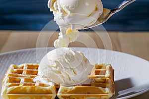 scooping vanilla ice cream onto waffle