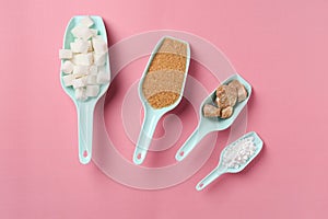 Scoops with different kinds of sugar and sweetener tablets on color background