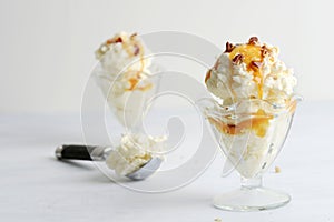 scoops of vanilla ice cream with pecans and caramel sauce