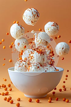 Scoops of Vanilla Ice Cream with Sprinkles Falling into Bowl on Warm Orange Background