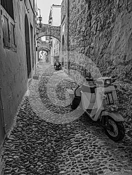 Greek Rhodes old town motorbike scooter alleyway. Black and white.