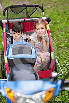 Scooter with little girl and boy in cart on