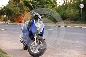 Scooter moped near a 50 Km/h speed limit indicator