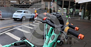 Scooters for rental stand near building in urban area