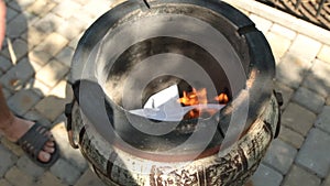 Scorching, heating tandoor. Ignition of paper and loading pieces of wood.