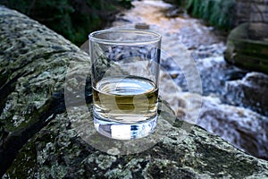 Scotch single malts or blended whisky spirits in glasses with water of river Spey on background, Scotland