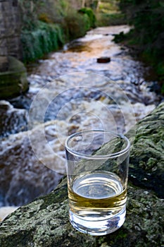 Scotch single malts or blended whisky spirits in glasses with water of river Spey on background, Scotland