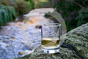 Scotch single malts or blended whisky spirits in glasses with water of river Spey on background, Scotland