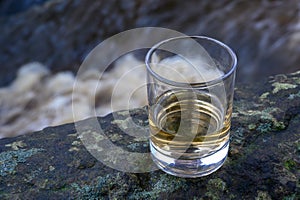 Scotch single malts or blended whisky spirits in glasses with water of river Spey on background, Scotland