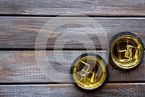 Scotch - two glasses with ice - on dark wooden background top-down frame copy space