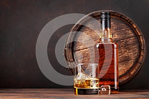 Scotch whiskey bottle, glass and old barrel