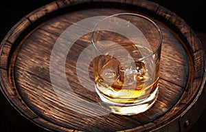 Scotch whiskey glass and old barrel