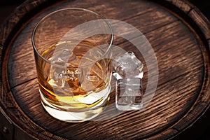 Scotch whiskey glass and old barrel