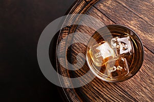 Scotch whiskey glass and old barrel