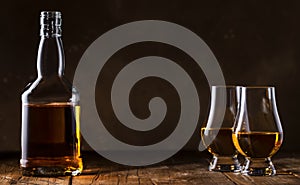 Scotch Whiskey without ice in glasses and bottle, rustic wood background, copy space banner