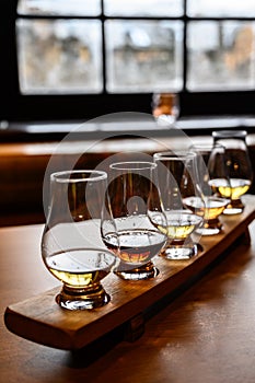 Scotch whisky, tasting glasses with variety of single malts or blended whiskey spirits on distillery tour in Scotland