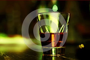 Scotch on wooden background with copyspace. An old and vintage countertop with highlight and a glass of hard liquor