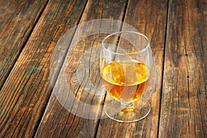 Scotch on wooden background with copyspace. An old and vintage table with glass of liquor .