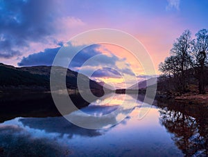 Scottish beautiful colorful sunset landscape with Loch Voil, mountains and forest at Loch Lomond & The Trossachs National Park