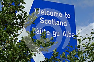 Scottish border sign, view through trees.