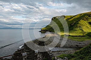 Scottish landscape with hills and shoreline near Staffin at Isle of Skye with ruins of old diatomite factory