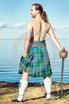 Scottish man with sword near the sea