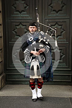 Scottish piper playing his bagpipe.