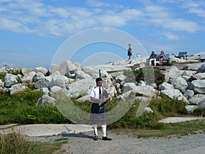 Scottish Piper Playing Bagpipes at Peggy`s Cove, Nova Scotia