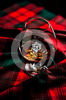 Scottish whiskey in a glass  on tartan background