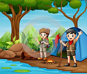 Scout boy and girl in uniform exploring the forest
