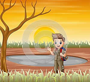 The scout boy standing under a dry tree