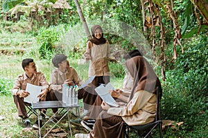 Scout teenage girls lead a briefing of friends while gathering