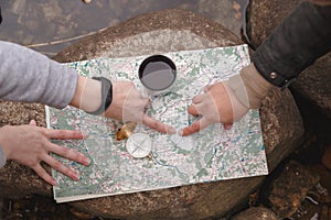 Scout tourists plan the route, orientate on the terrain on the map and the compass. View from above photo