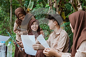 Scout youths chat and do clipboard assignments together